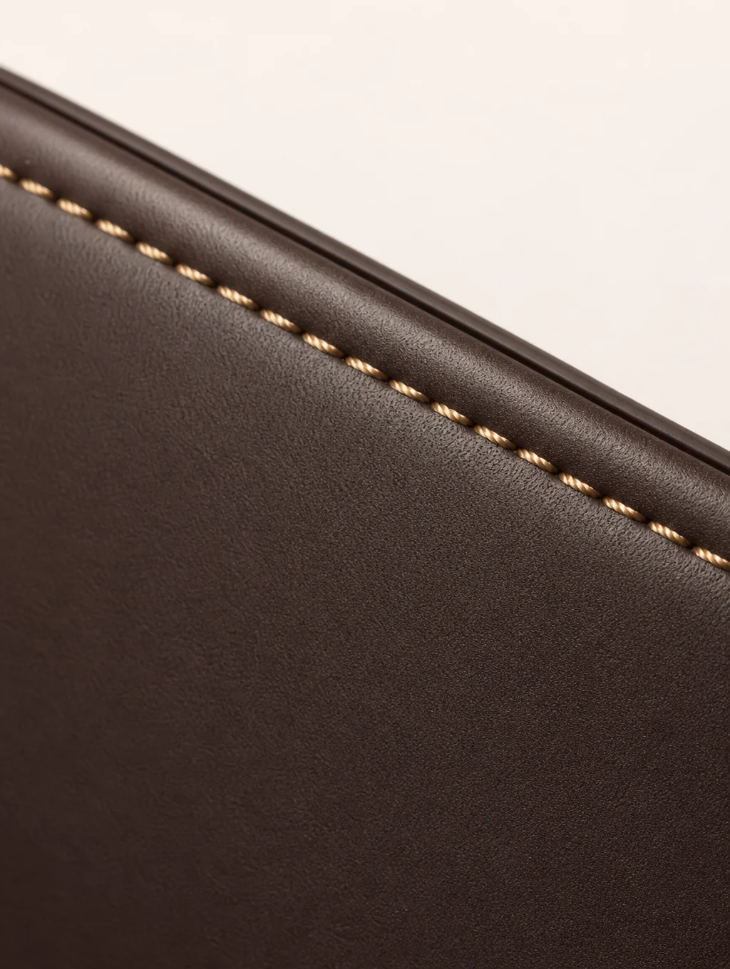 Macro detail of precision reinforced stitching on handbag leather
