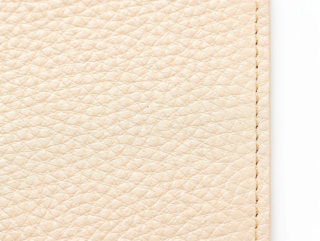 Macro detail of custom hardware and precision stitching on leather handbag